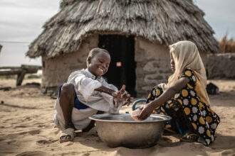 Mahamat y Sara se lavan las manos en la puerta de su vivienda en la comunidad de Kamkalaga. En esta región de Chad donde los recursos hídricos son muy escasos Oxfam Intermón ha rehabilitado dos pozos de agua y ha instalado un tanque en el centro de salud.