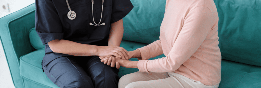Profesional de la salud brindando apoyo y agarrando la mano de una mujer