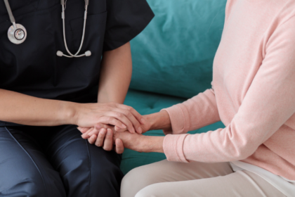 Profesional de la salud brindando apoyo y agarrando la mano de una mujer