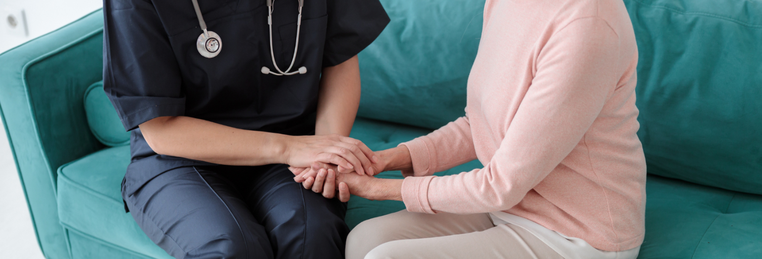 Profesional de la salud brindando apoyo y agarrando la mano de una mujer