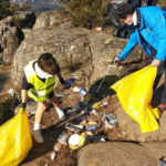 Voluntarios recogiendo basura en el monte