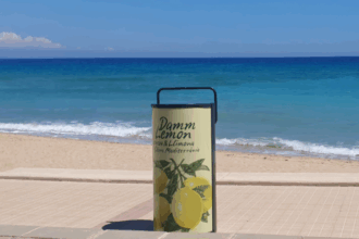 Máquina compactadora de latas Damm instalada frente a la playa