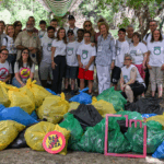 Foto grupal de los y las voluntarias junto con la Reina Sofía