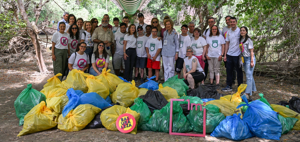 Foto grupal de los y las voluntarias junto con la Reina Sofía