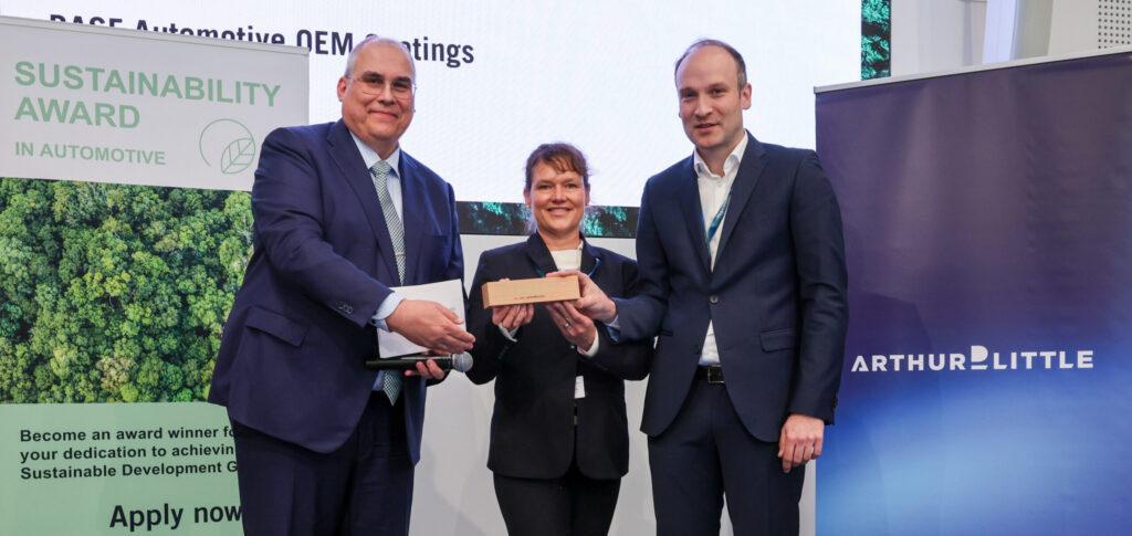 El Dr. Steffen Rohlmann (derecha), Desarrollo de Basecoat EMEA, y Sonja Glanemann (centro), Global Sustainability Manager, Automotive OEM Coatings, reciben el prermio Sustainability Award en Automotive 2026 - Imagen cedida por BASF Coatings