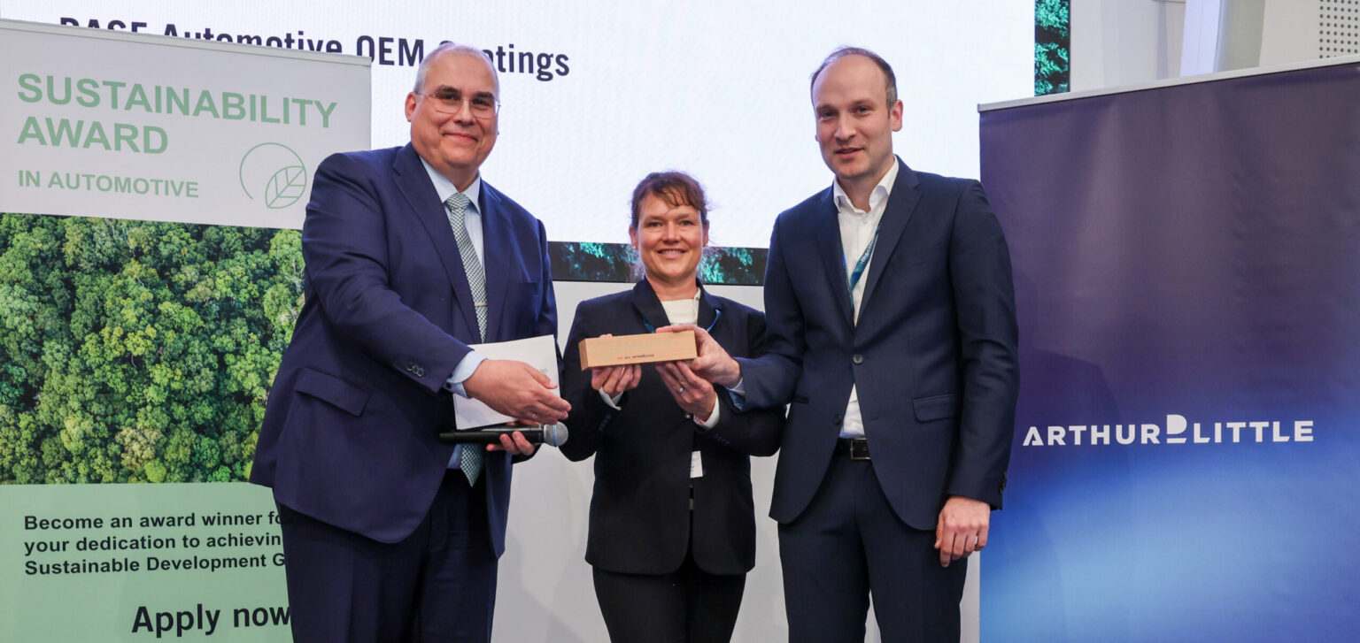 El Dr. Steffen Rohlmann (derecha), Desarrollo de Basecoat EMEA, y Sonja Glanemann (centro), Global Sustainability Manager, Automotive OEM Coatings, reciben el prermio Sustainability Award en Automotive 2026 - Imagen cedida por BASF Coatings