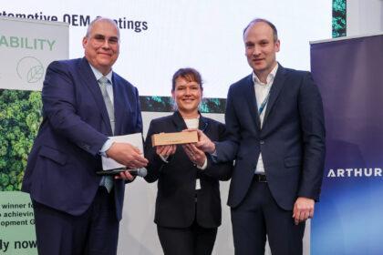 El Dr. Steffen Rohlmann (derecha), Desarrollo de Basecoat EMEA, y Sonja Glanemann (centro), Global Sustainability Manager, Automotive OEM Coatings, reciben el prermio Sustainability Award en Automotive 2026 - Imagen cedida por BASF Coatings