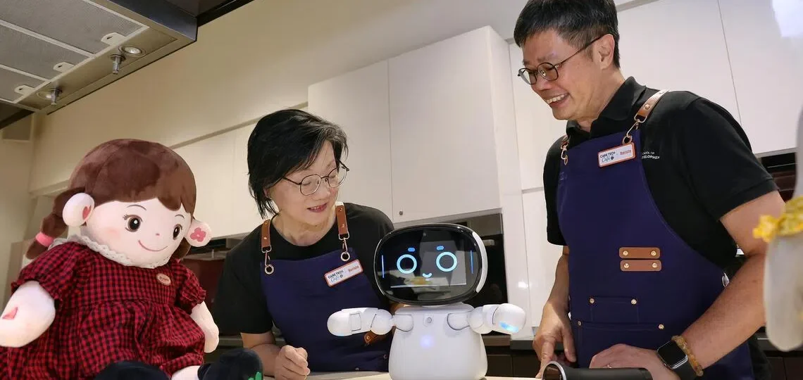 El profesor asociado de SUSS, Kelvin Tan (derecha), explica las características de un robot a Emily Choo, residente de Kampong Chai Chee, en el Care Tech Cafe de Heartbeat@Bedok el 31 de julio. FOTO DE ST: KEVIN LIM
